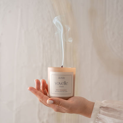 Hand holding a blown-out Voyelle candle with smoke rising