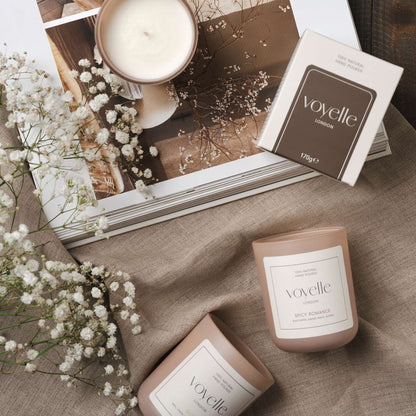 Voyelle candles on linen fabric with baby's breath flowers and an open magazine