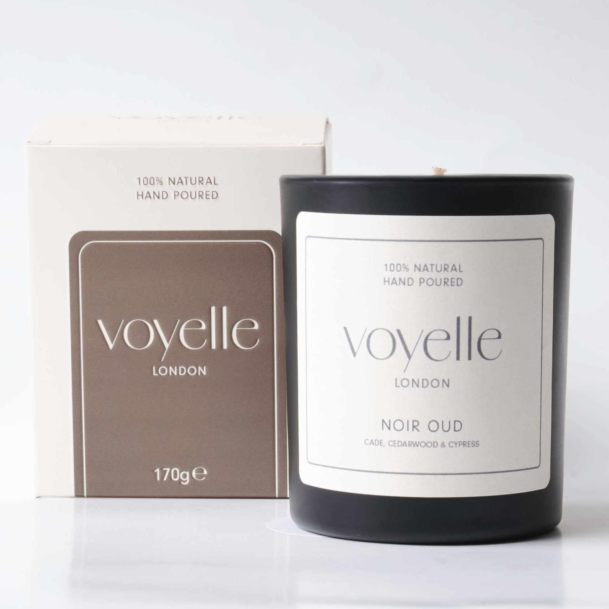 Voyelle London Noir Oud candle in black glass with packaging box, labeled as 100% natural and hand poured