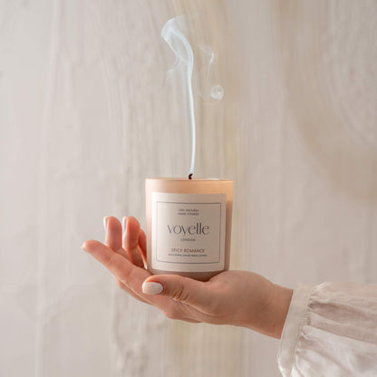 Extinguished Voyelle Spicy Romance candle held in hand with smoke rising from the wick