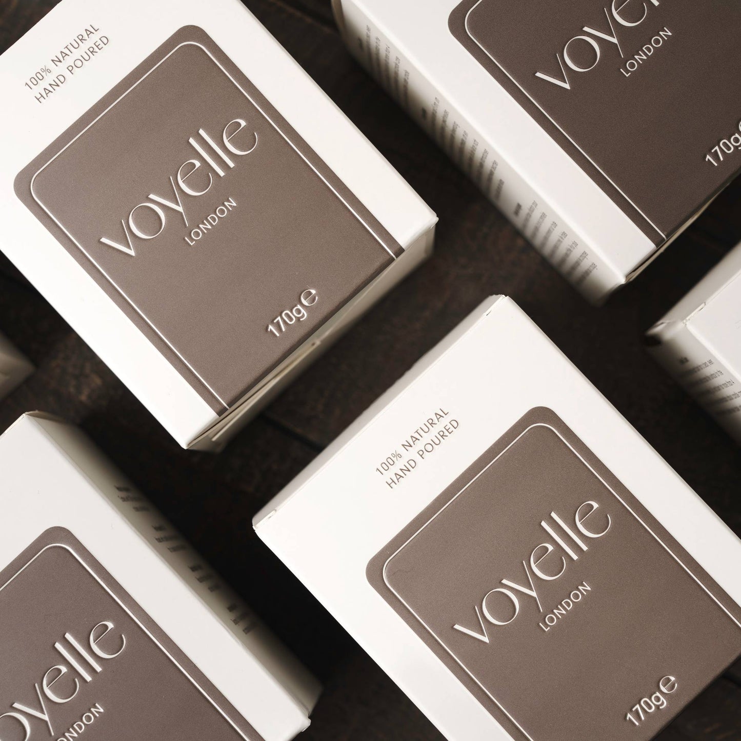 Multiple Voyelle candle boxes arranged on a dark surface