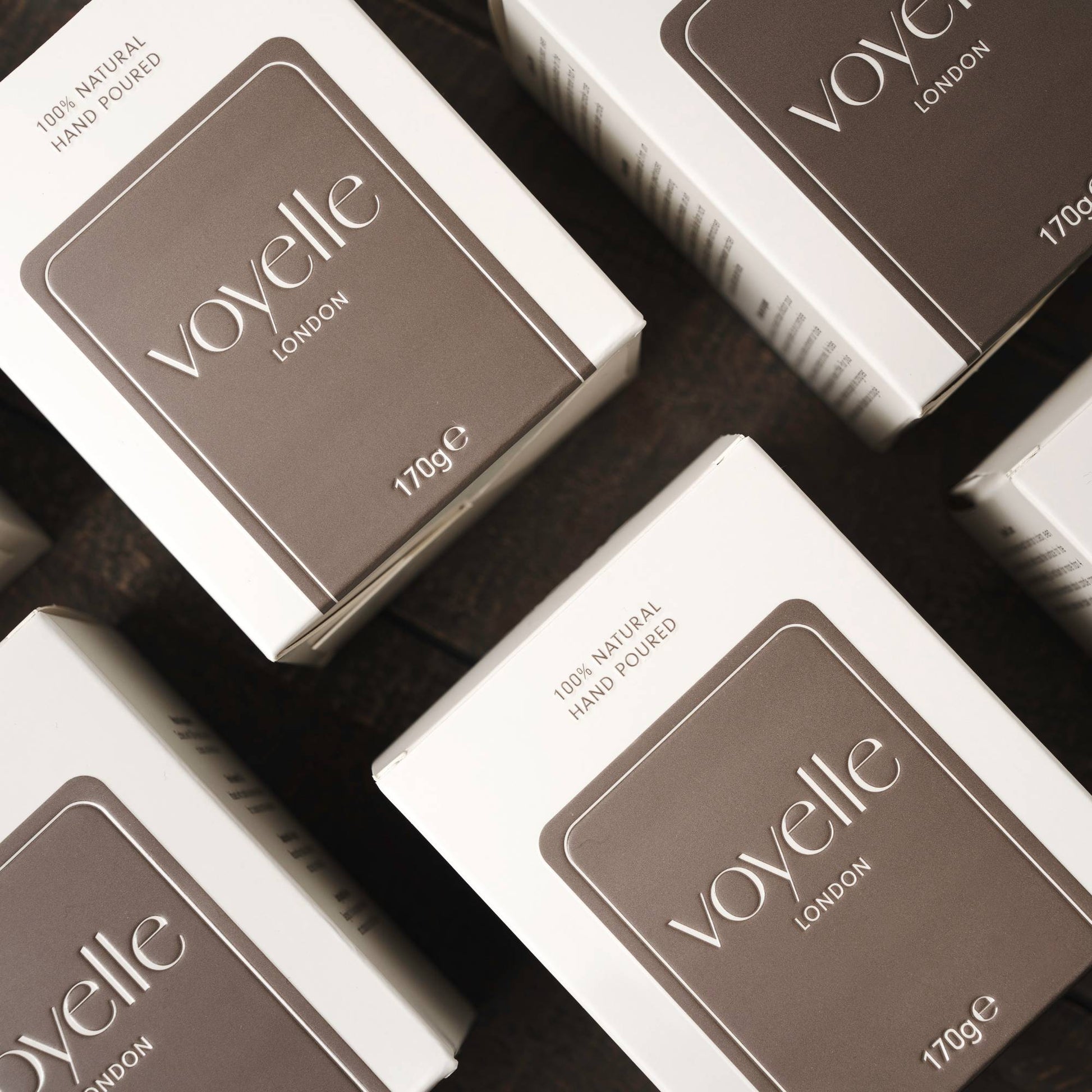 Multiple Voyelle candle boxes arranged on a dark surface