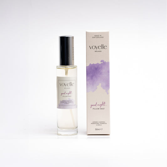 Sleep pillow mist sprayed onto a made bed in soft evening light — lavender & cedarwood