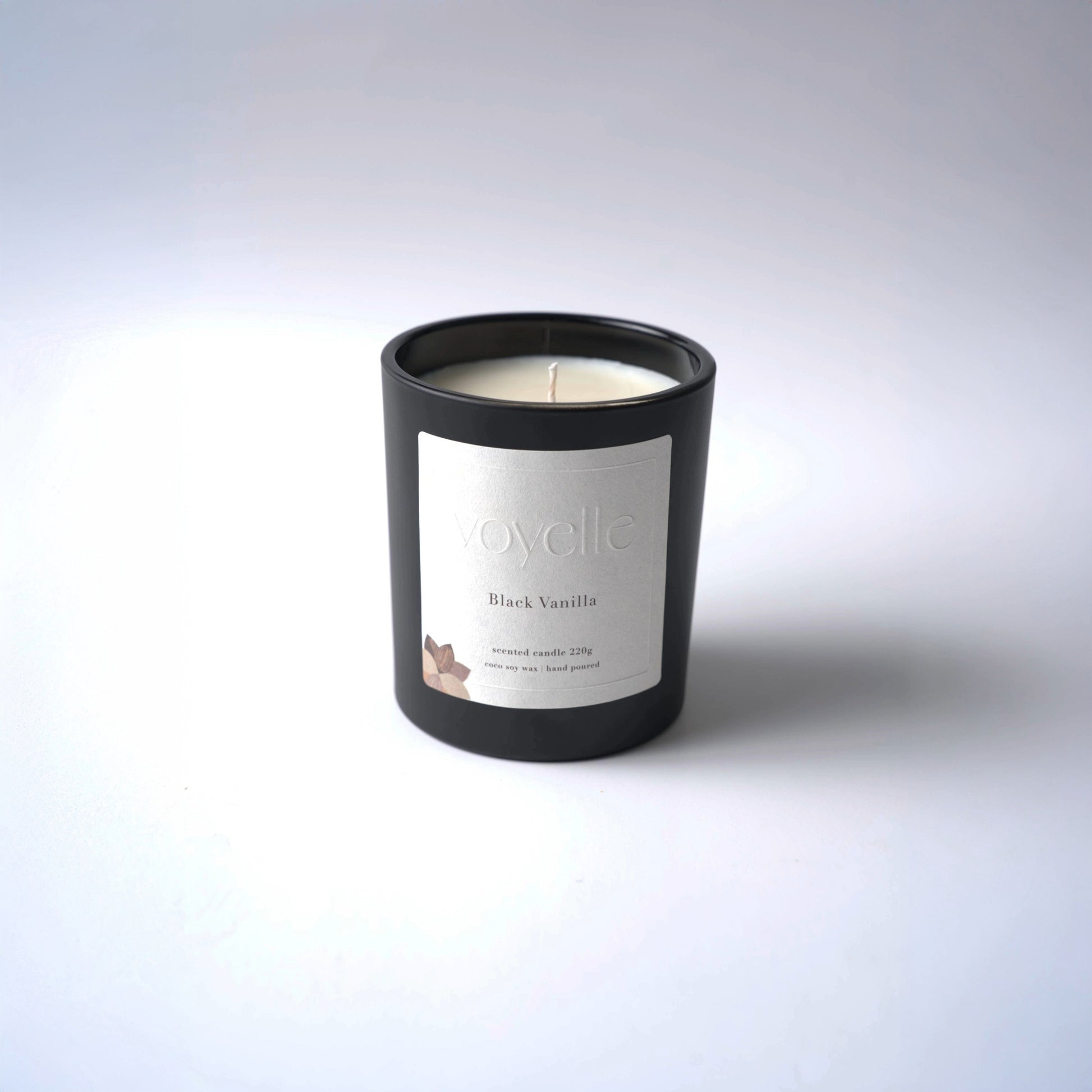 Voyelle Black Vanilla scented candle in matte black jar on minimal white background
