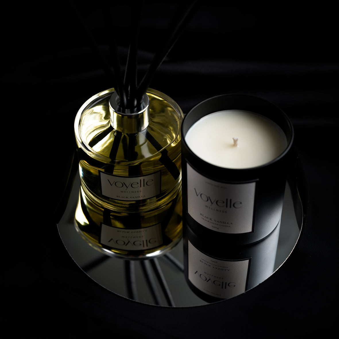 Black Vanilla reed diffuser and candle on a round black mirror