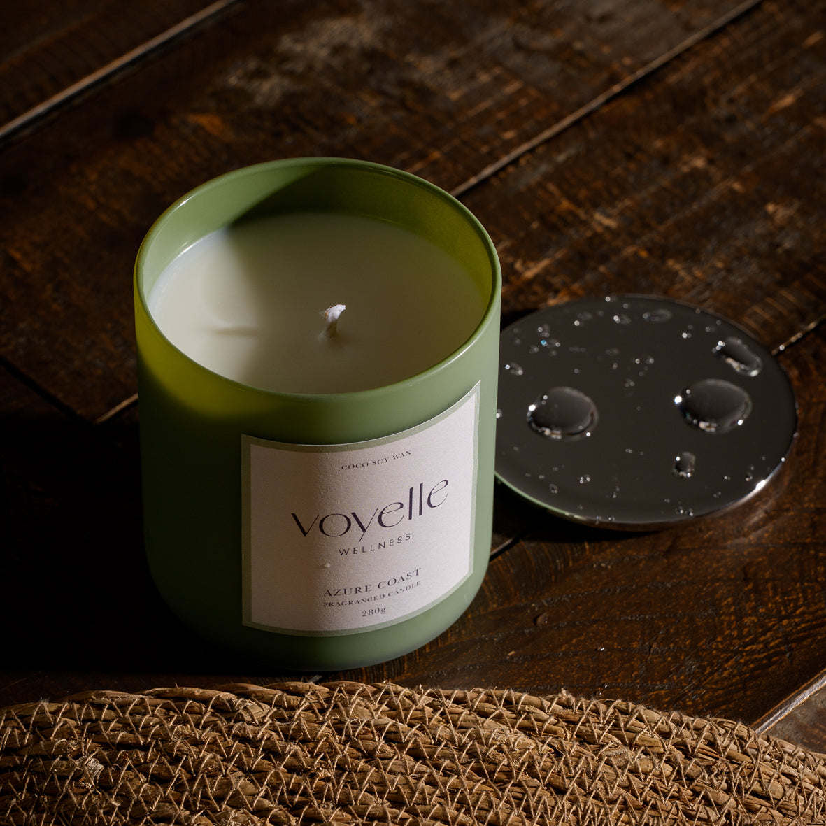 Azure Coast candle open on dark wood, its chrome lid beside
