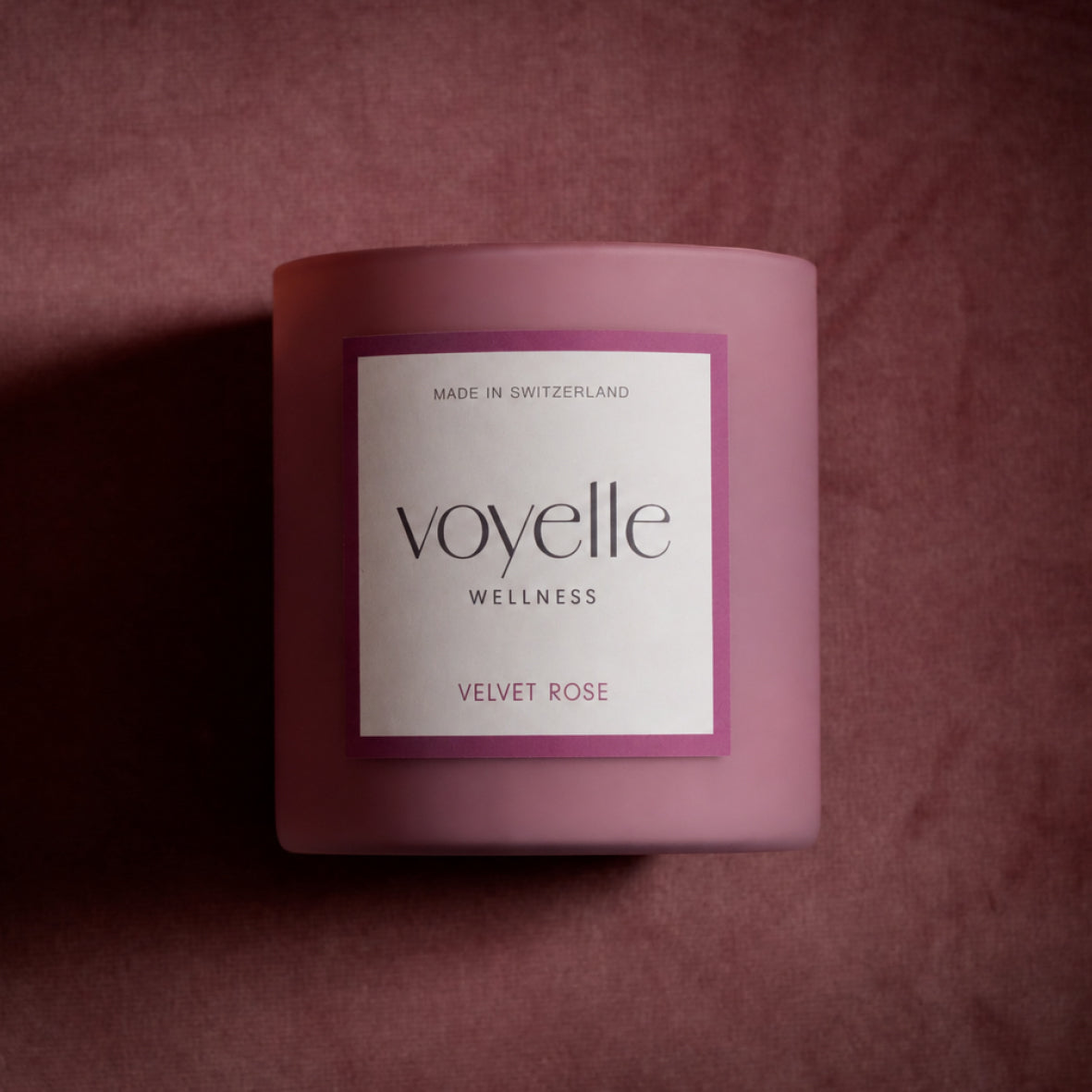 Velvet Rose candle on dusty-rose velvet in dramatic side light